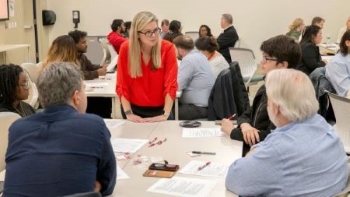 RISE academy director Cindy Goodwin-Sak with students in the program at a table talking